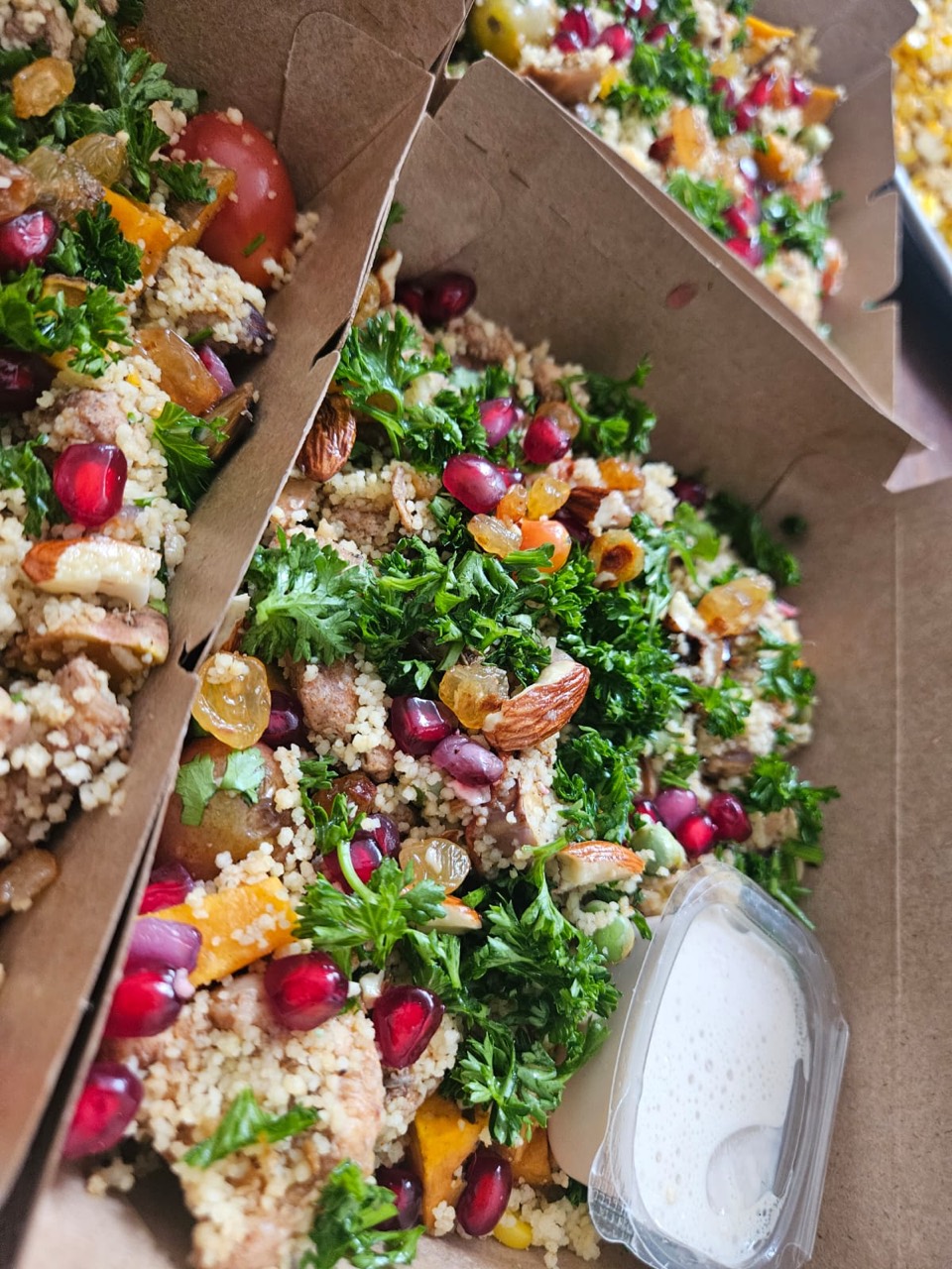 Colourful couscous salad bowls with herbs, nuts, and pomegranate