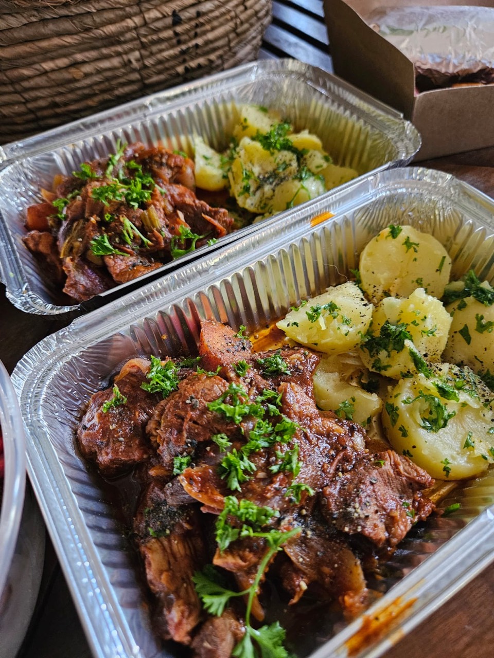 Slow-cooked meat with herbed potatoes in meal trays